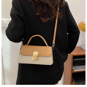 Model trägt eine Vintage-Umhängetasche in Braun und Creme mit goldener Schnalle