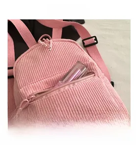 Detailed close-up of pink corduroy mini backpack front zipper pocket with lip gloss
