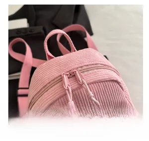 Close-up of pink corduroy backpack featuring smooth dual zippers and durable carry handle