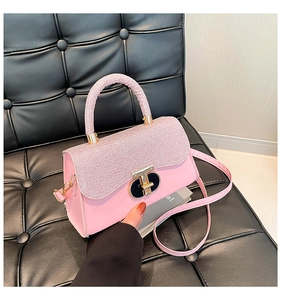 Macro detail of pink handbag showing shimmering sequin flap and gold T-lock clasp