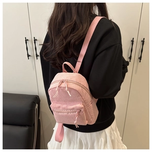 Gros plan du mini sac à dos en velours côtelé rose avec texture douce et fermeture