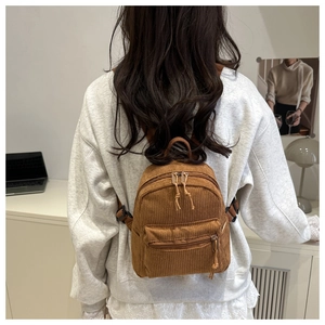 Brauner Cord-Mini-Rucksack im Detail mit strukturierter Oberfläche und Fronttasche