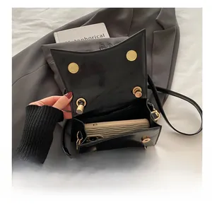 Close-up of black crossbody bag showing interior capacity with golden magnetic buckle