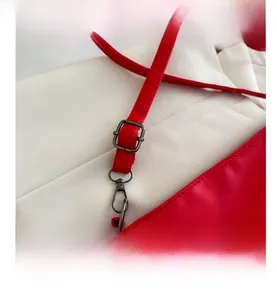 Detail of red leather tote bag showing gunmetal adjustable buckle and sturdy shoulder strap