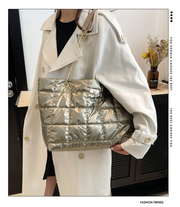 Detail view of metallic quilted tote bag with large squares and elegant chain straps