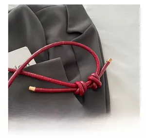 Detail of red crocodile embossed leather shoulder bag with gold metal hardware