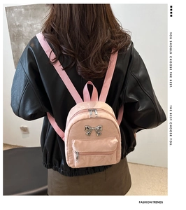 Vue arrière d'un mannequin portant le mini sac à dos rose avec un détail de nœud argenté