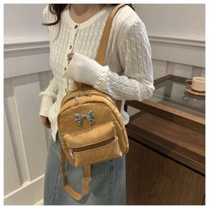 Détail d'un sac à dos camel en cuir PU texturé avec un nœud métallique argenté élégant