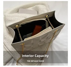 Detail view of cream quilted tote bag showing large interior capacity and gold chain