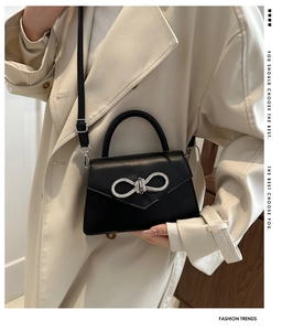 Fashionable black crossbody bag featuring a sparkling rhinestone bow on smooth PU leather