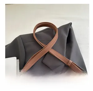 Detail of adjustable brown leather shoulder strap with silver buckle and fine stitching