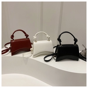 Detailed trio of vintage hourglass crossbody bags in burgundy, white, and black leather