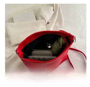 Interior view of the spacious red leather bucket bag showing capacity for daily essentials