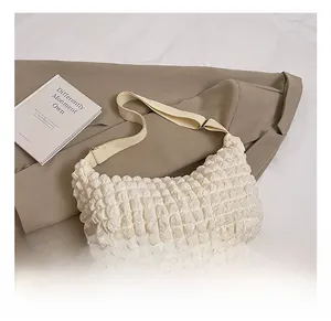 Close-up of cream white popcorn texture shoulder bag with stylish wide woven strap