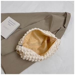 Detailed view of cloud puff bag showing bubble texture and yellow inner lining