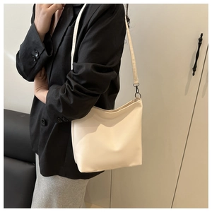Détail du sac seau plissé crème avec texture cuir souple et crochets métalliques