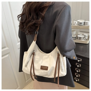 Detailed back view of a white shoulder bag with brown straps and long leather tassels