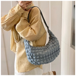 Detail showing blue bubble pleated fabric and crescent shape of the stylish tote bag