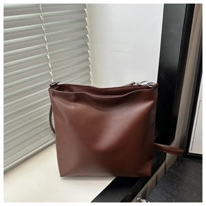 Gros plan d'un sac seau en cuir PU marron foncé avec crochets en argent et fermeture éclair