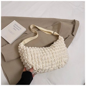 Macro shot of white bubble textured fabric on a stylish crossbody bag with strap