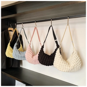Five popcorn texture crescent bags in various colors hanging on a retail display rack