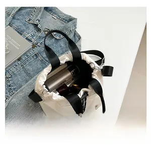 Spacious white canvas tote bag with drawstring closure showing daily essentials inside