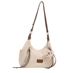 Creamy white nylon tote bag with brown straps and cute pink bear charm on white background