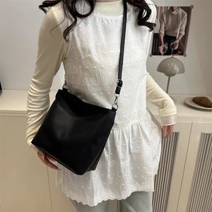 Sac seau noir minimaliste en cuir mat avec une forme carrée élégante et épurée