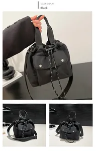 Macro view of black nylon drawstring bucket bag with buckle pocket and dual straps