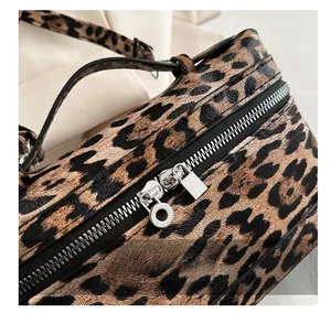 Macro view of leopard print bag featuring smooth silver-tone dual metal zippers