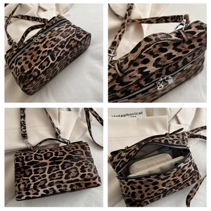 Detail of leopard print box bag showing zipper, interior capacity, and adjustable strap
