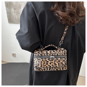 Close-up of leopard print crossbody bag styled with a black wool coat for winter