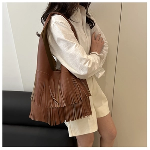 Detail shot of brown tassel shoulder bag featuring vintage pebbled leather texture