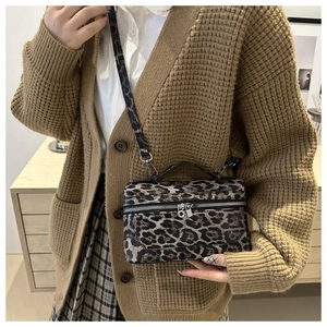 Close-up of leopard print mini box bag with silver zipper and top handle detail