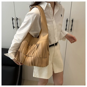 Close-up of camel litchi grain leather hobo bag featuring stylish long double tassels