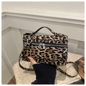 Detailed macro of leopard print vanity bag with silver double zippers and top handle