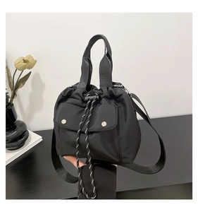 Detail einer schwarzen Nylon-Beuteltasche mit breitem Gurt und silbernen Metallschnallen