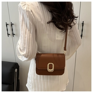 Brown crossbody lock bag worn by model showing the sophisticated stylish upper body fit