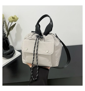 Detail der grauen Nylon-Beuteltasche mit Kordelzug und vorderer Tasche mit Druckknopf