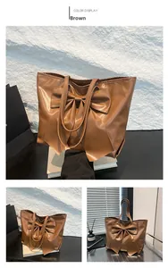 Détail du grand nœud décoratif marron et de la texture en cuir synthétique brillant du sac