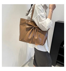 Détail du grand sac cabas en cuir marron orné d'un grand nœud décoratif élégant