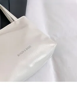 Gros plan du sac fourre-tout blanc minimaliste avec texture PU et texte FASHION & BAGS