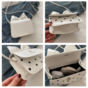 Vues détaillées du mini sac à bandoulière blanc avec nœud et détails à pois noirs