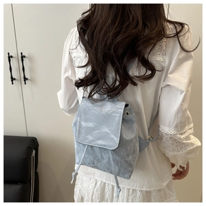 Mini sac à dos bleu clair avec texture plissée et fermeture à cordon sur modèle