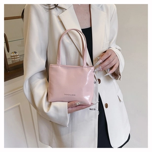 Vue détaillée du sac à main rose en cuir verni avec inscription FASHION & BAGS gravée