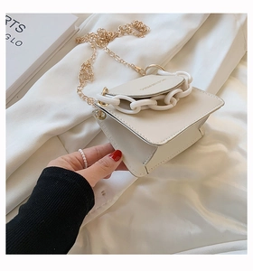 Detailansicht cremeweiße Minitasche mit weißer Deko-Kette und goldenem Metallriemen