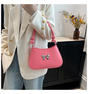 Sac à main rose avec nœud porté avec un blazer blanc et un jean pour un style urbain
