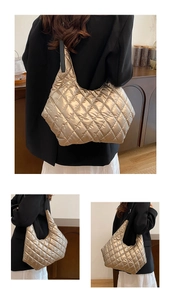 Detail of champagne gold quilted tote bag with classic diamond stitching and black straps