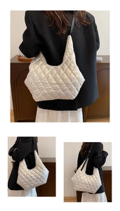 Detailed view of silver quilted tote bag with metallic finish and black shoulder strap