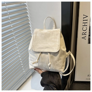 Vue détaillée du mini sac à dos crème avec texture plissée et fermeture à cordon